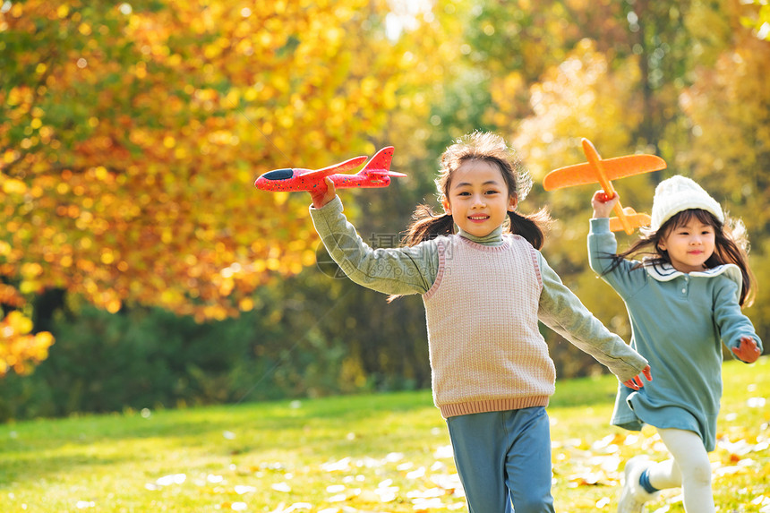 拿着玩具飞机在公园玩耍的女孩图片