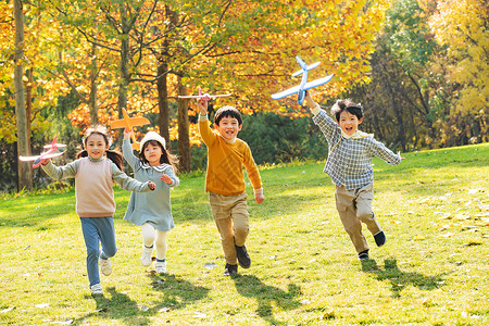 拿着玩具的女孩快乐儿童拿着玩具飞机在公园玩耍背景