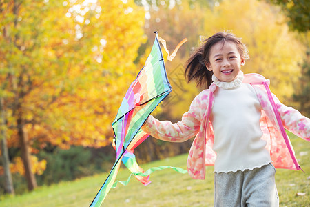 快乐的小女孩在公园里放风筝高清图片