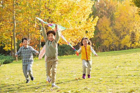 快乐的小朋友在公园里放风筝高清图片