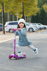 成长的道路快乐的小女孩在户外玩滑板车背景