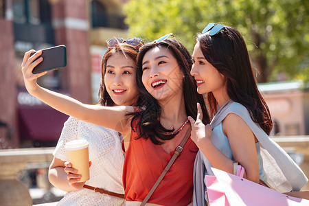 网红街拍年轻闺蜜用手机照相背景