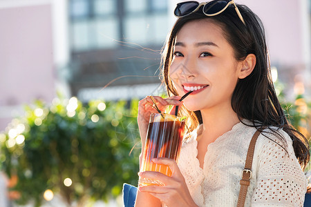 快乐的青年女人品尝夏日饮品高清图片