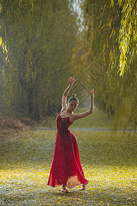 穿红色裙子的青年女人在户外跳芭蕾舞背景图片