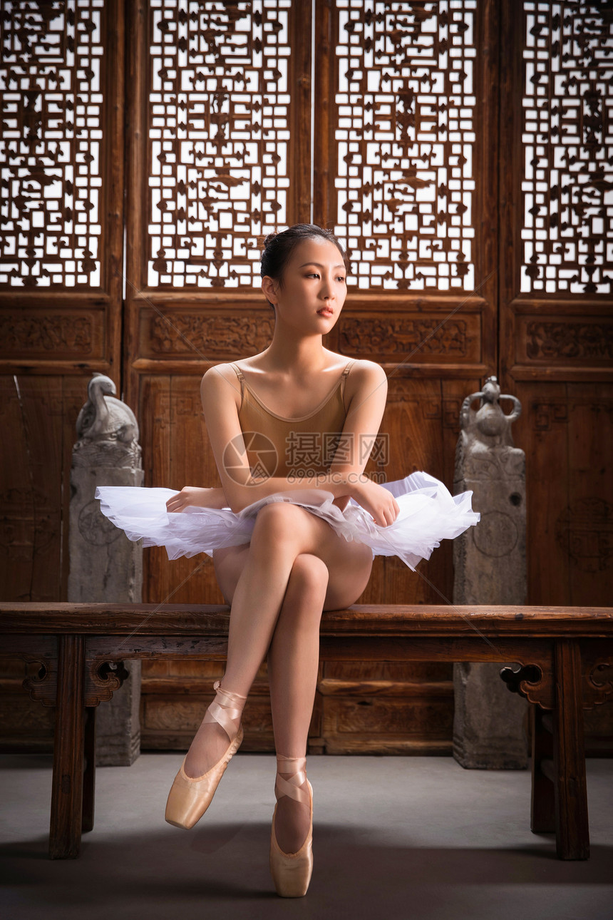 芭蕾舞演员坐在中式古典门前图片