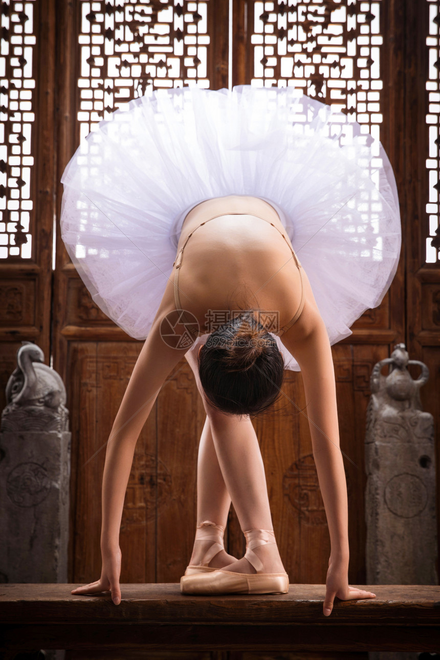 青年女人在中式古典门前跳芭蕾舞图片