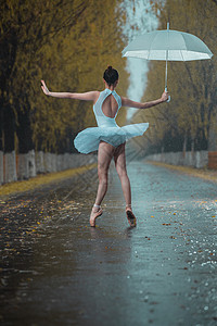 拿着雨伞的青年女人跳芭蕾舞背景图片