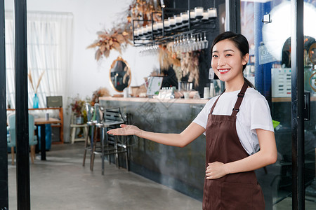 咖啡店门口迎接顾客的女服务员高清图片