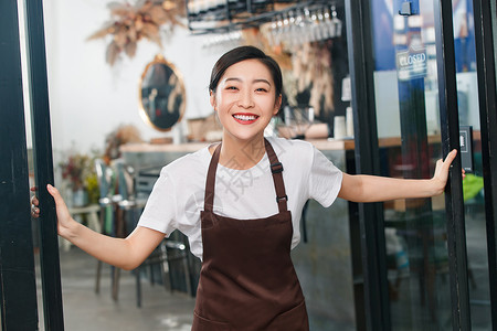 咖啡店门口迎接顾客的女服务员人高清图片素材