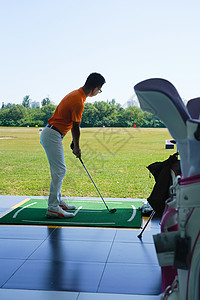 高尔夫练习场上青年男人打高尔夫图片