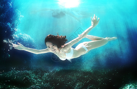 美女潜水员年轻女人在水下游泳背景