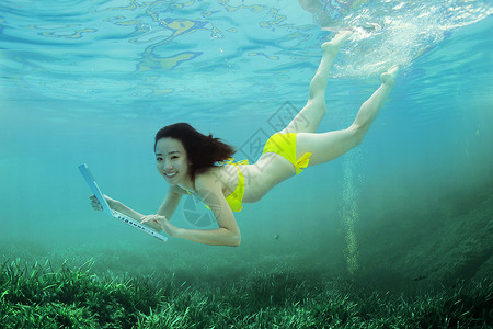 波科技年轻女人在水下使用电脑背景