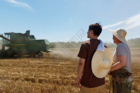 农民收割麦穗农田里实现机械化收割的农民背景