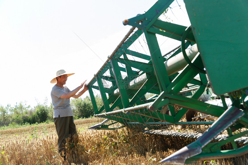 农田里实现机械化收割的农民图片