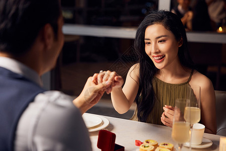 烛光晚餐为女性戴上戒指求爱高清图片素材