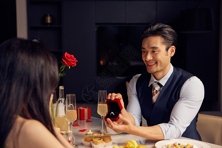男性餐桌上为女性展示戒指餐厅高清图片素材
