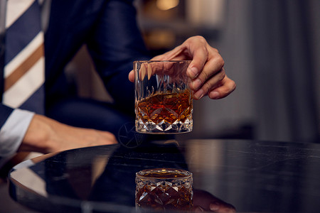 法国酒手拿威士忌酒杯特写背景