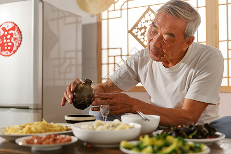 老年人坐在家里吃饭喝酒美味高清图片素材