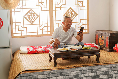 福字手机老年人坐在家里吃饭看手机背景