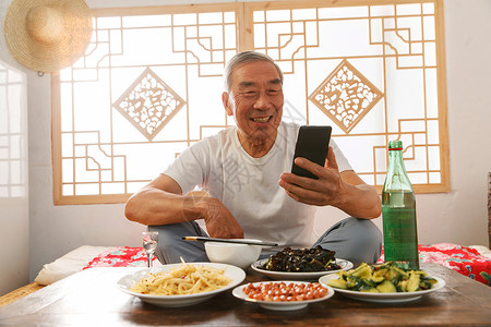 福字手机老年人坐在家里吃饭看手机背景