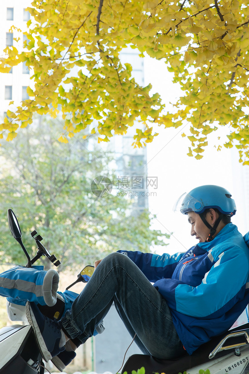 外卖员坐在摩托车上休息图片