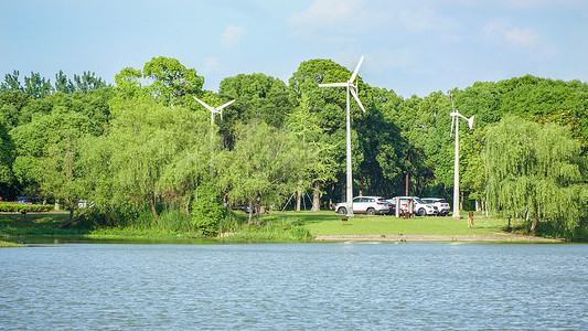 地球生态树湖边的新能源风力发电风车背景