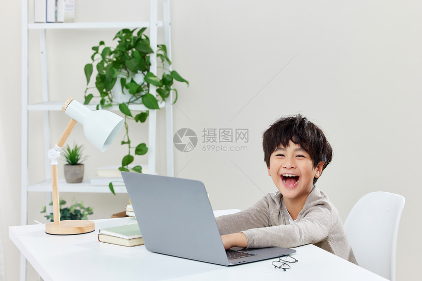 书桌前上网课的小男孩图片