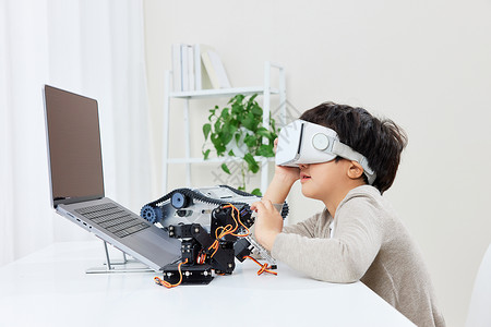 创新赢未来小男孩带vr眼镜操作编程机器人背景