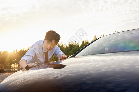 白领男性擦拭汽车外部漆面高清图片