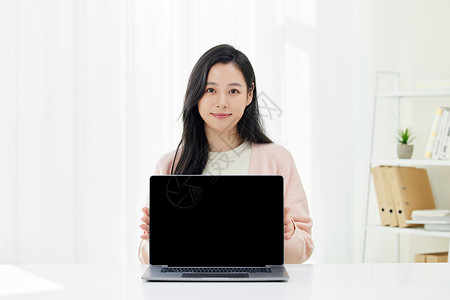 年轻女性展示电脑屏幕背景图片