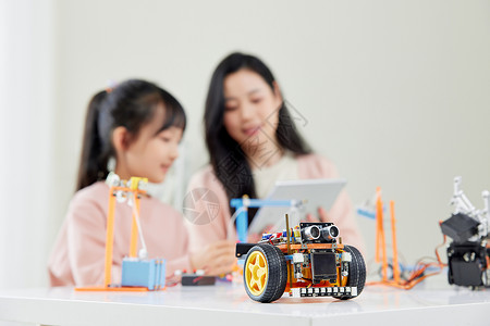 儿童与机器人妈妈和女儿一起学习操作机器人编程背景