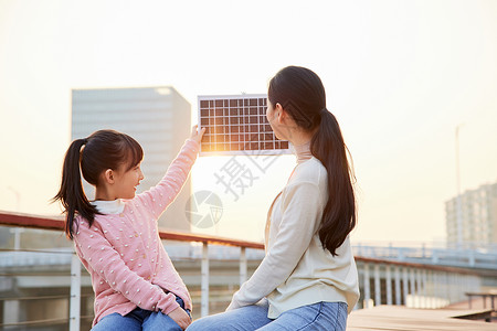 妈妈带女儿户外体验太阳能板背景图片