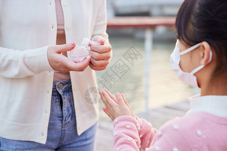 女性凝胶户外母女使用凝胶护手消毒特写背景