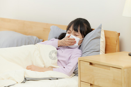 一个口罩小女孩生病卧床咳嗽背景
