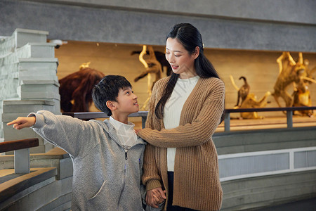 学生参观博物馆年轻妈妈带儿子参观展览背景