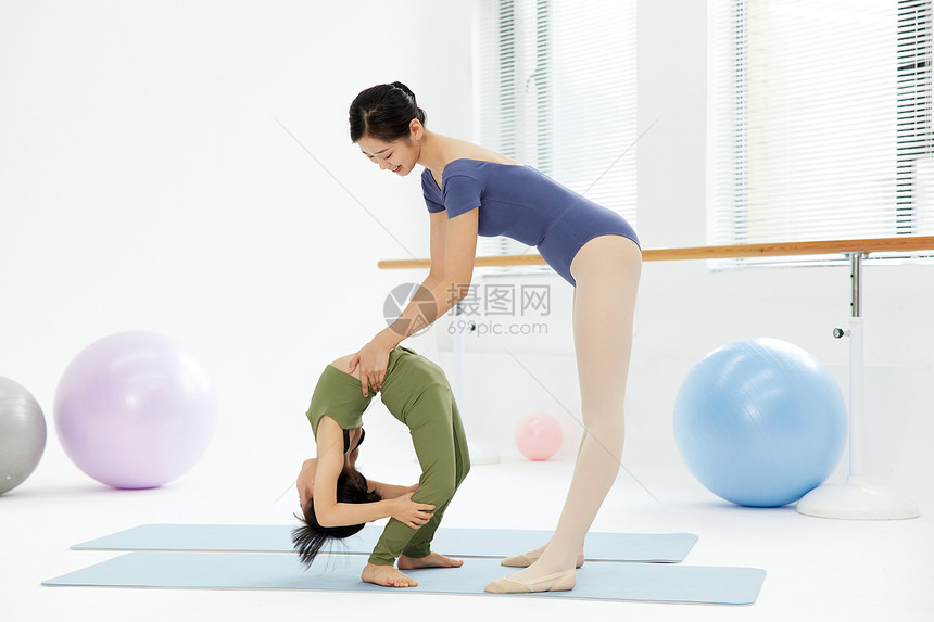 体操老师锻炼小女孩柔韧性图片