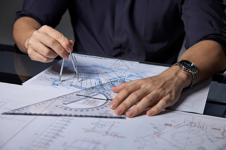 在手上指南针建筑设计师在桌上画图特写背景