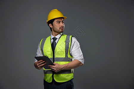 工人手拿工具手拿平板电脑的建筑工人背景