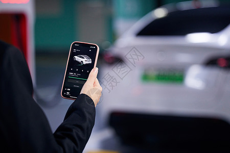 绿色充电使用手机操控新能源汽车特写背景