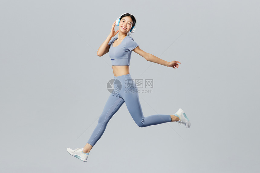 创意跳跃健身女性戴耳机听歌健身图片