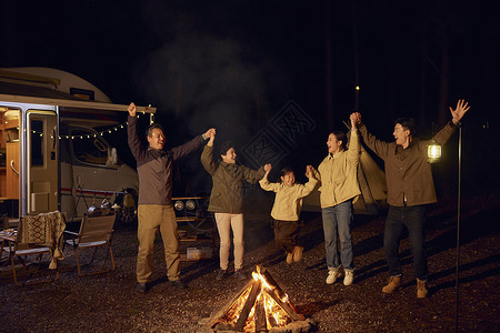 一大家庭夜晚户外露营篝火跳舞图片