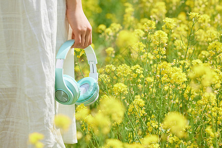 春景素材油菜花海手中的耳机特写背景