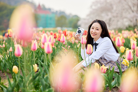 春季踏青手拿照相机的制服少女高清图片