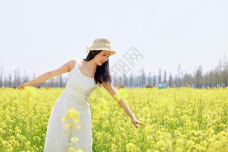 春天站在油菜花田里的美女图片