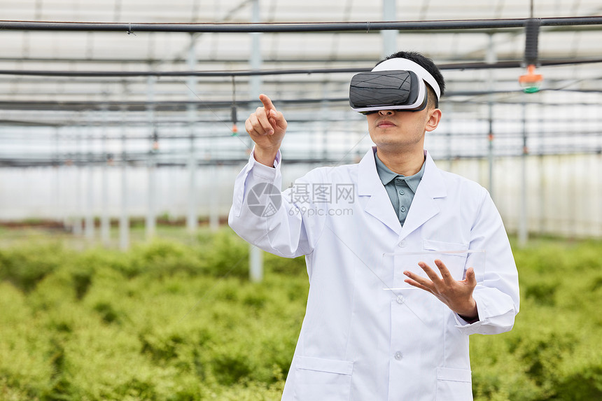 植物大棚戴着vr眼镜点击虚拟屏幕的人图片