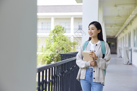 校园里手拿书本的女大学生图片素材