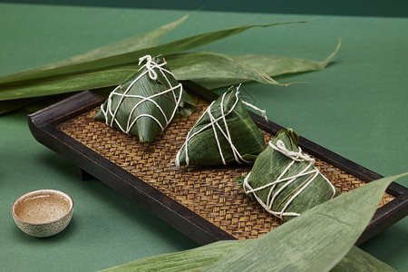 中国传统美食绿色桌面放着茶水和粽子背景