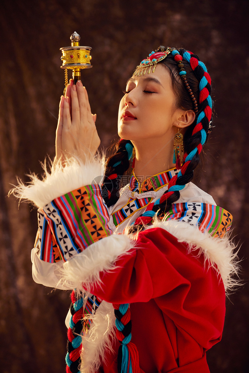 手拿经轮祈祷的藏族女性图片