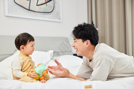 床上的年轻奶爸和宝宝婴儿高清图片素材