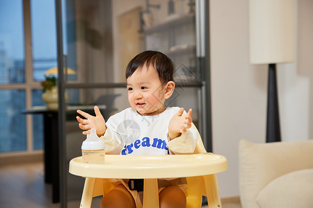 木质高档婴儿椅坐在宝宝椅上开心微笑的婴幼儿背景